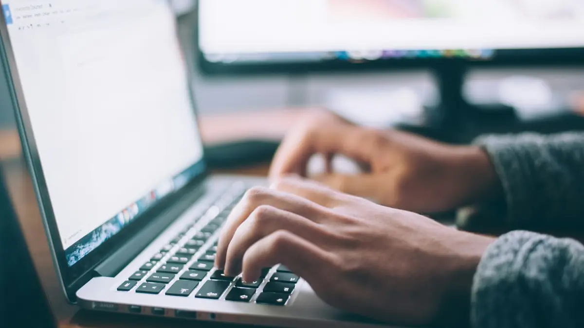 Người dùng gõ phím trên laptop, đọc chính sách bảo mật trước khi gửi thông tin