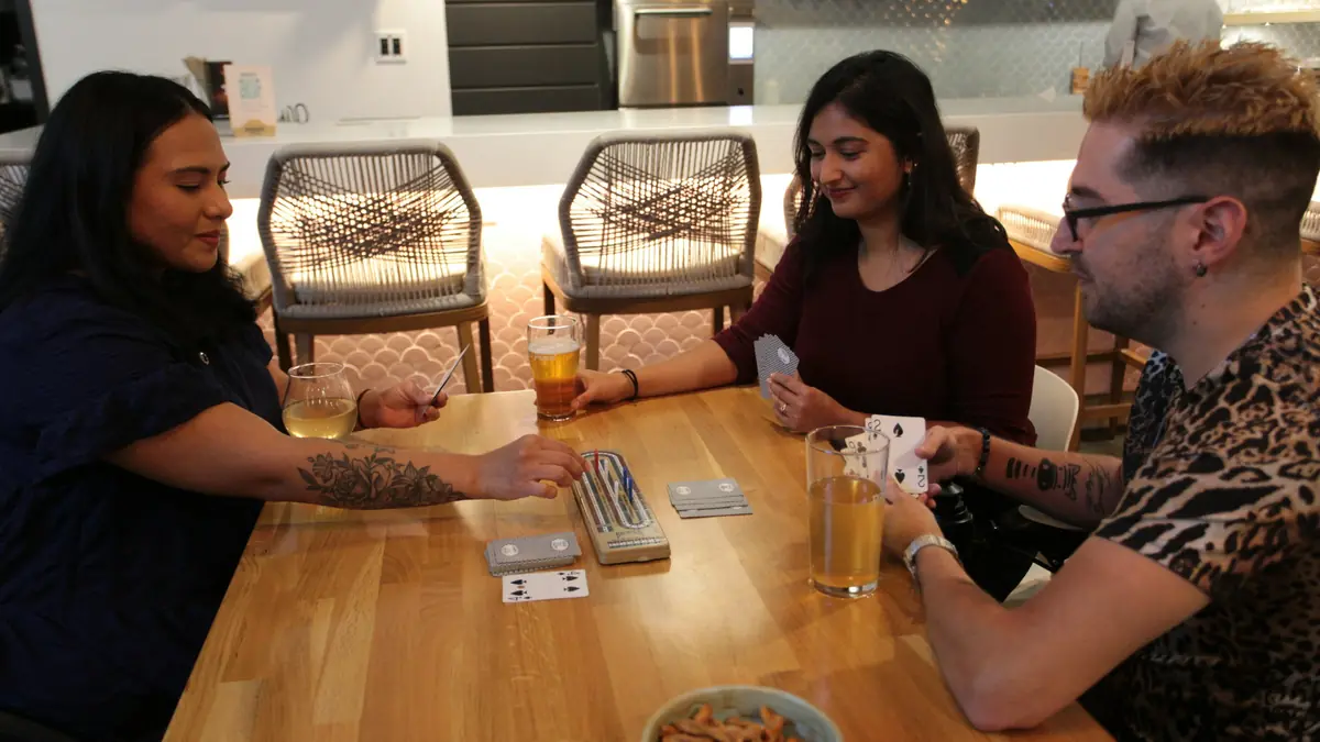 Nhóm bạn đánh bài quanh bàn gỗ, minh họa game bài tại Sunwin